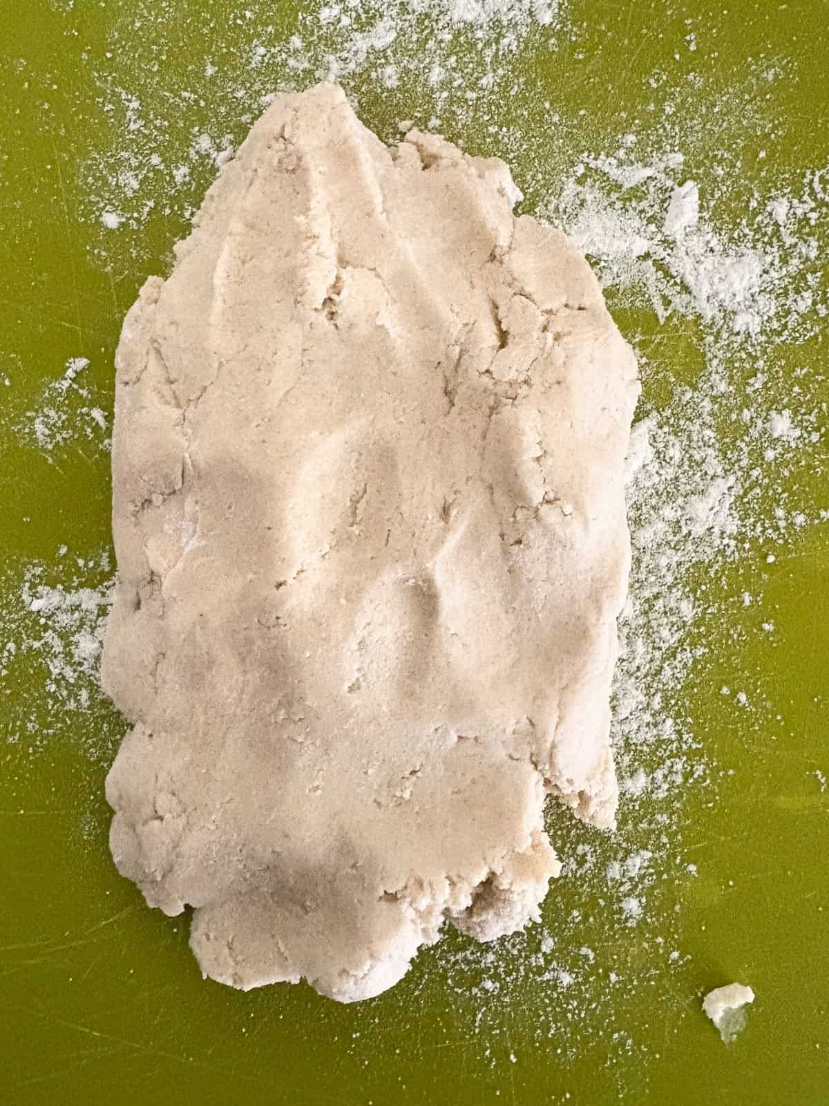 Tender and just lightly sweet gluten free cream biscuits are made in just one bowl with a handful of simple ingredients! Gluten free cream biscuit dough patted out on a cutting board.