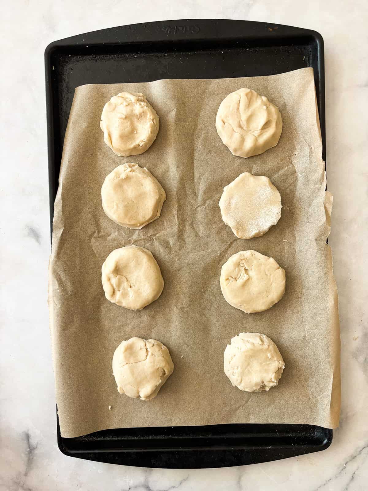 Tender and just lightly sweet gluten free cream biscuits are made in just one bowl with a handful of simple ingredients! Gluten Free Cream biscuits on a baking sheet.