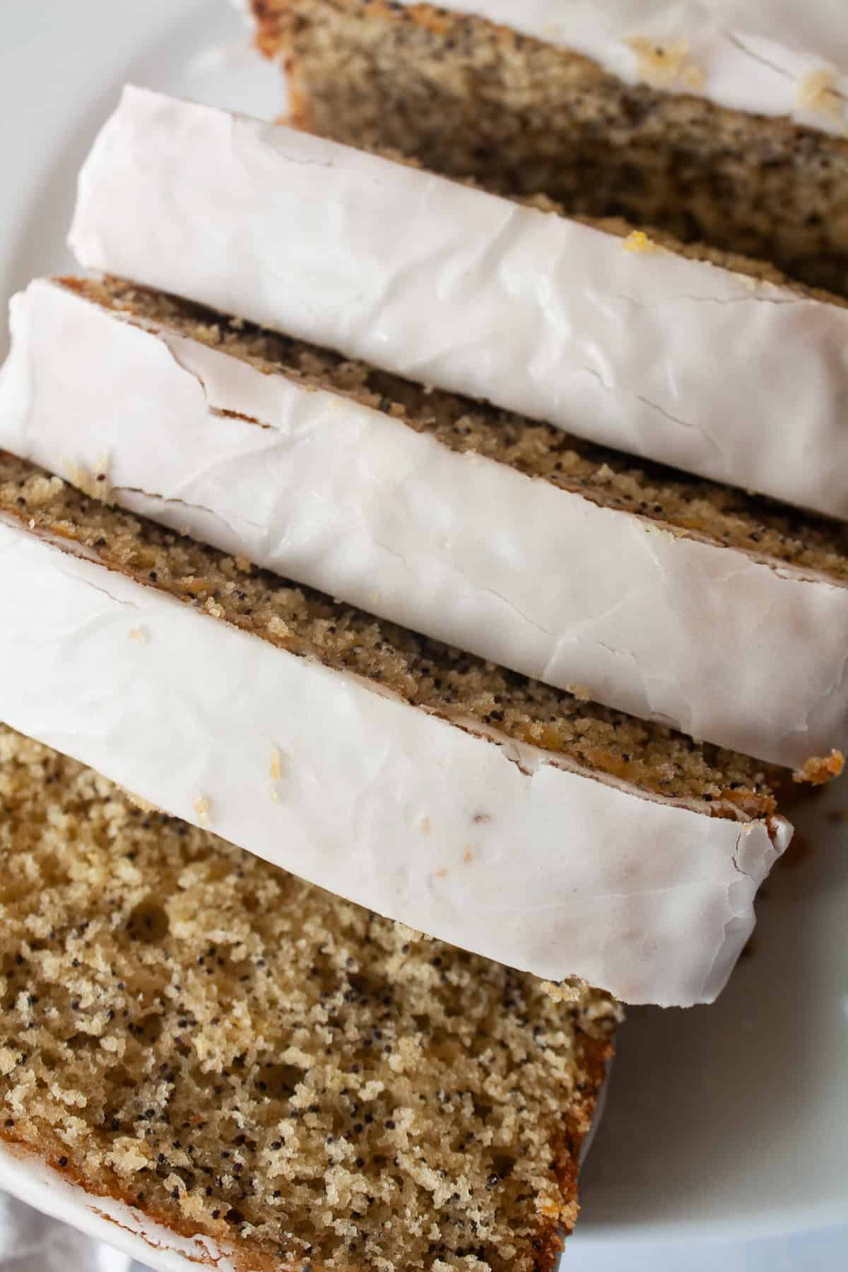 A tender, gorgeously sliceable gluten free lemon poppyseed bread topped with a bright, thick lemon glaze for maximum flavor. A top down shot of a loaf of sliced gluten free lemon poppyseed bread.