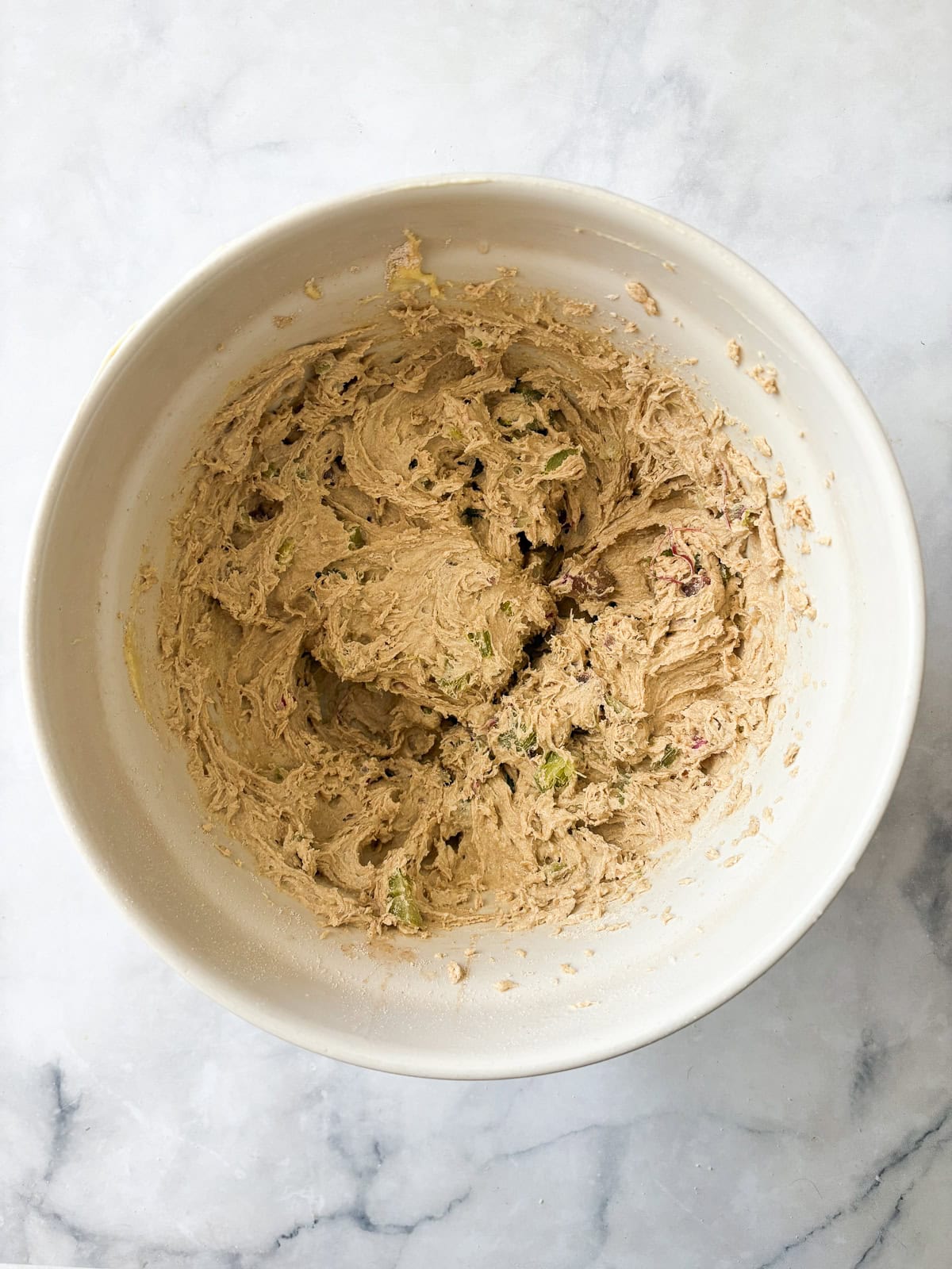 Tart rhubarb is the star of this gluten free rhubarb cake, with jammy pockets of rhubarb and a soft-crumbed cake that's just sweet enough. Batter for gluten free rhubarb cake in a bowl.