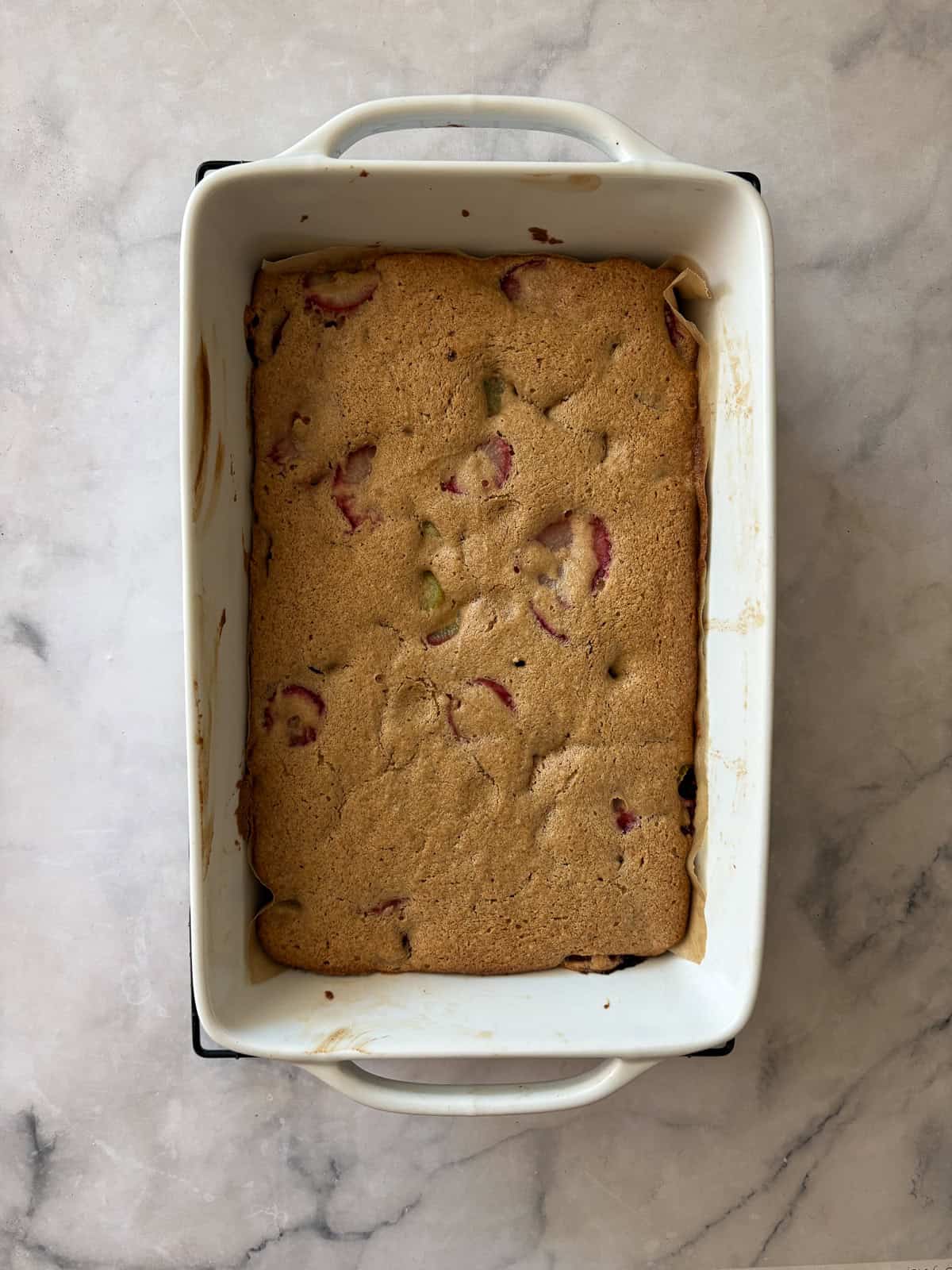 A soft, buttery gluten-free strawberry rhubarb cake packed with fresh fruit. Fork-tender, easy to make, and perfect for summer dessert. A baked pan of strawberry rhubarb cake.