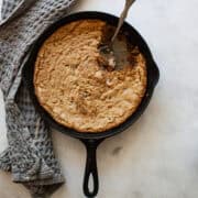 A serving spoon rests in a gluten free skillet cookie.