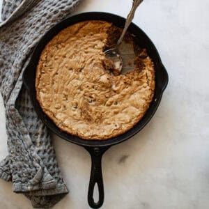 A serving spoon rests in a gluten free skillet cookie.