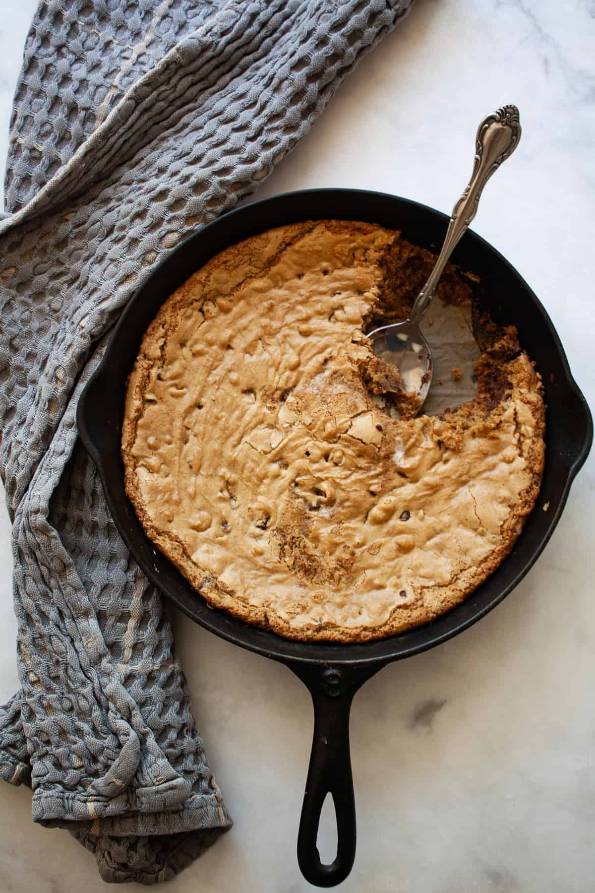 A gluten free skillet cookie with a spoon in it.