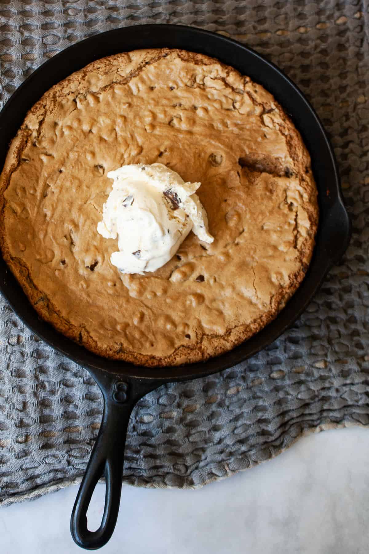 This sweet and chewy gluten free skillet cookie that's soooo good served warm and topped with ice cream. Made in one bowl! A scoop of ice cream tops a gluten free skillet cookie.