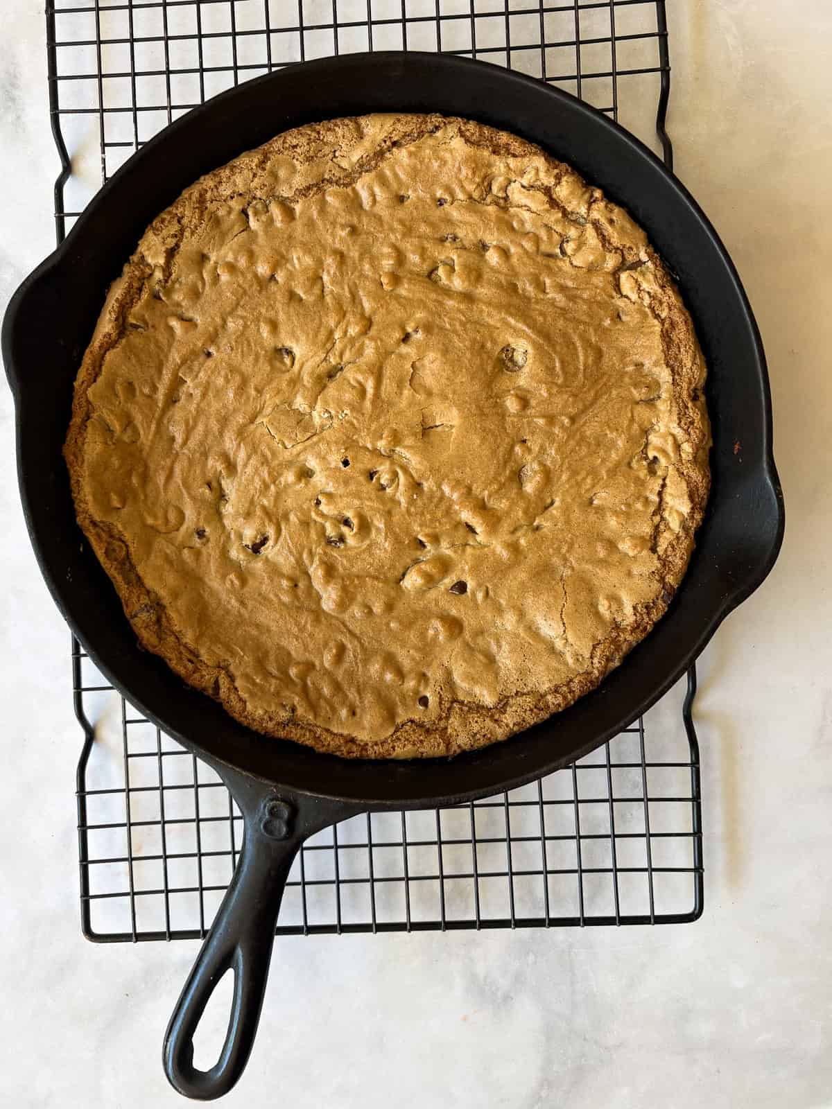 This sweet and chewy gluten free skillet cookie that's soooo good served warm and topped with ice cream. Made in one bowl! A gluten free skillet cookie cools on a wire rack.