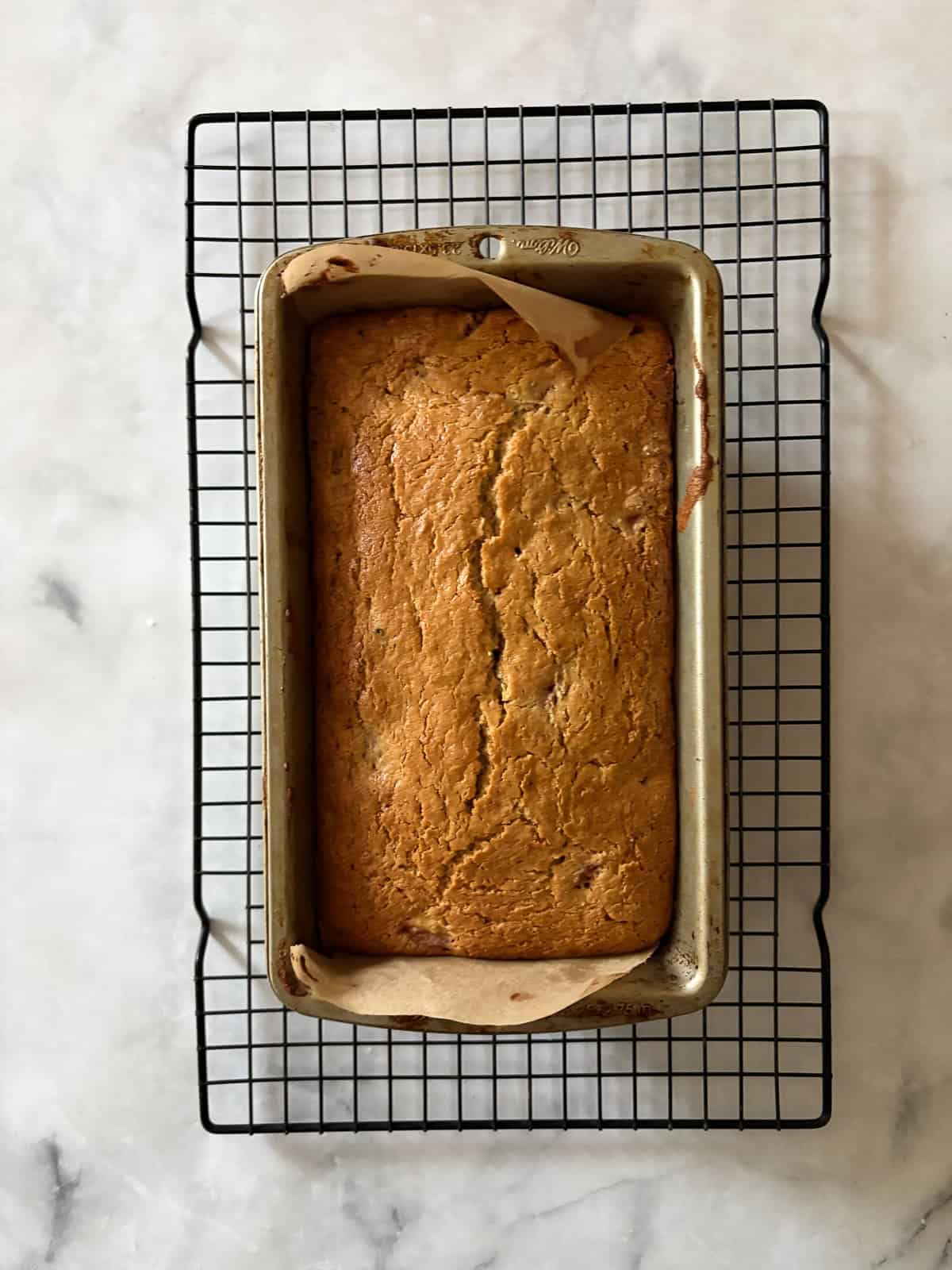A tender, fruit-flecked gluten-free strawberry loaf cake topped with a simple and sweet vanilla glaze. The best summery bake! A gluten free strawberry loaf cake cools in the pan.