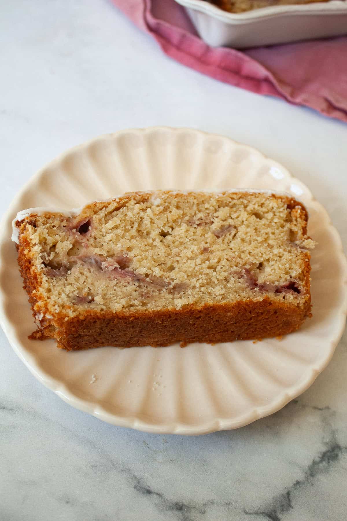 A big slice of gluten free strawberry loaf cake on a plate.