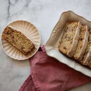 A slice of gluten free strawberry loaf cake on a plate and slices in a serving dish.