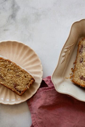 A slice of gluten free strawberry loaf cake on a plate and slices in a serving dish.