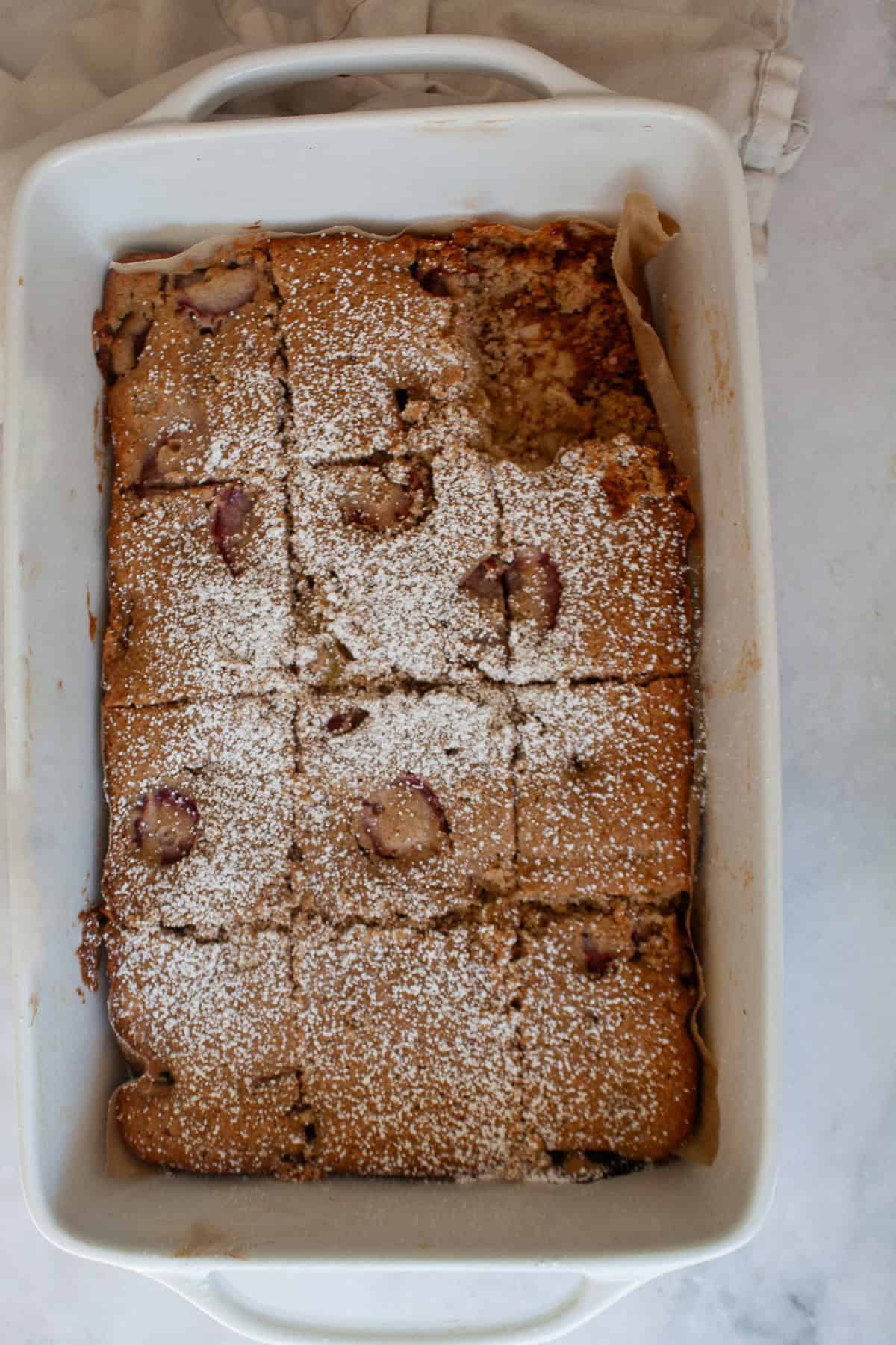 A soft, buttery gluten-free strawberry rhubarb cake packed with fresh fruit. Fork-tender, easy to make, and perfect for summer dessert. A sliced up gluten free strawberry rhubarb cake in a pan.