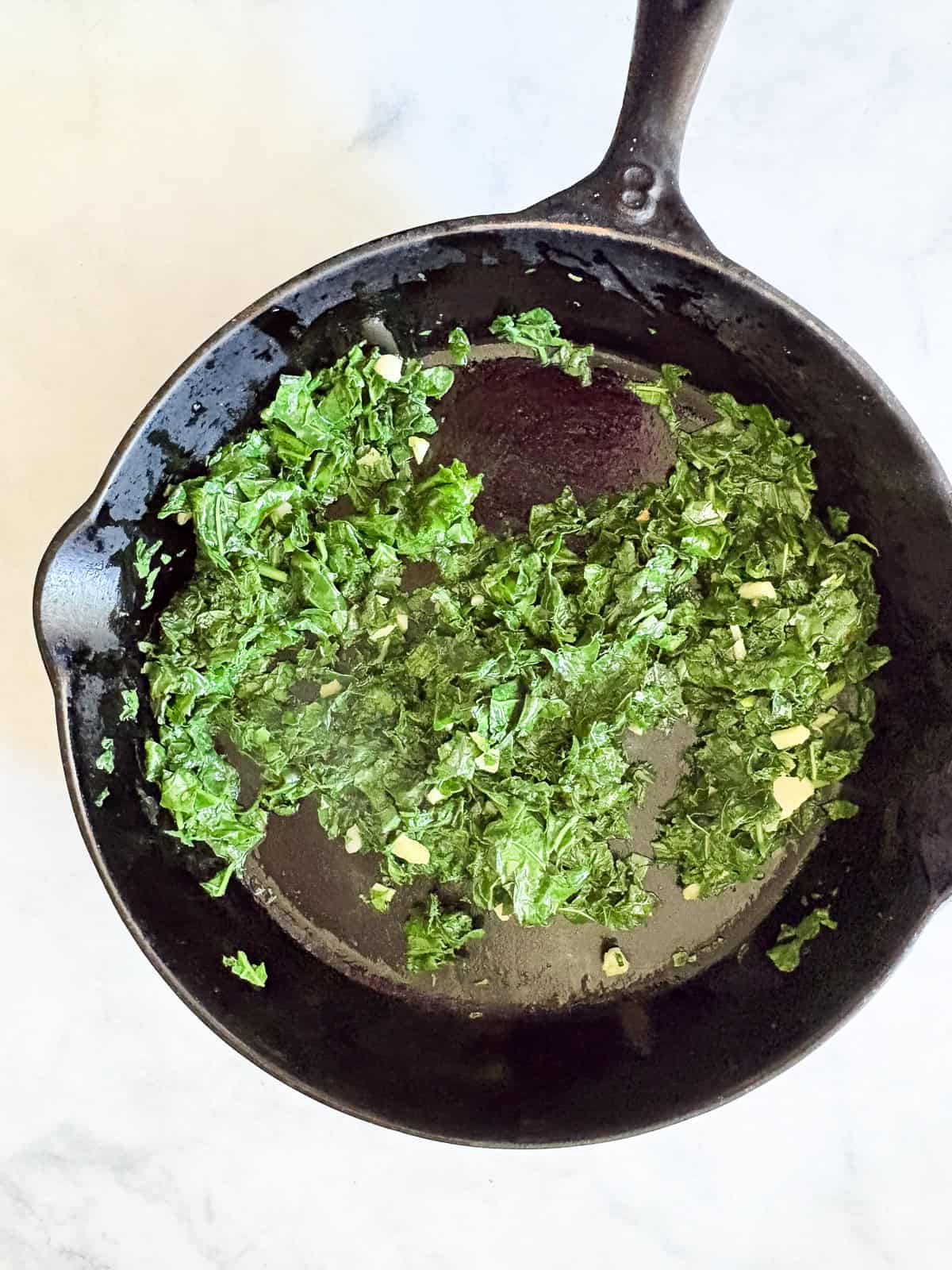 Garlicky white beans and kale are brightened up with lemon juice for a simple, satisfying, and QUICK vegetarian main. Chopped kale cooks in a skillet with garlic for white beans and kale.