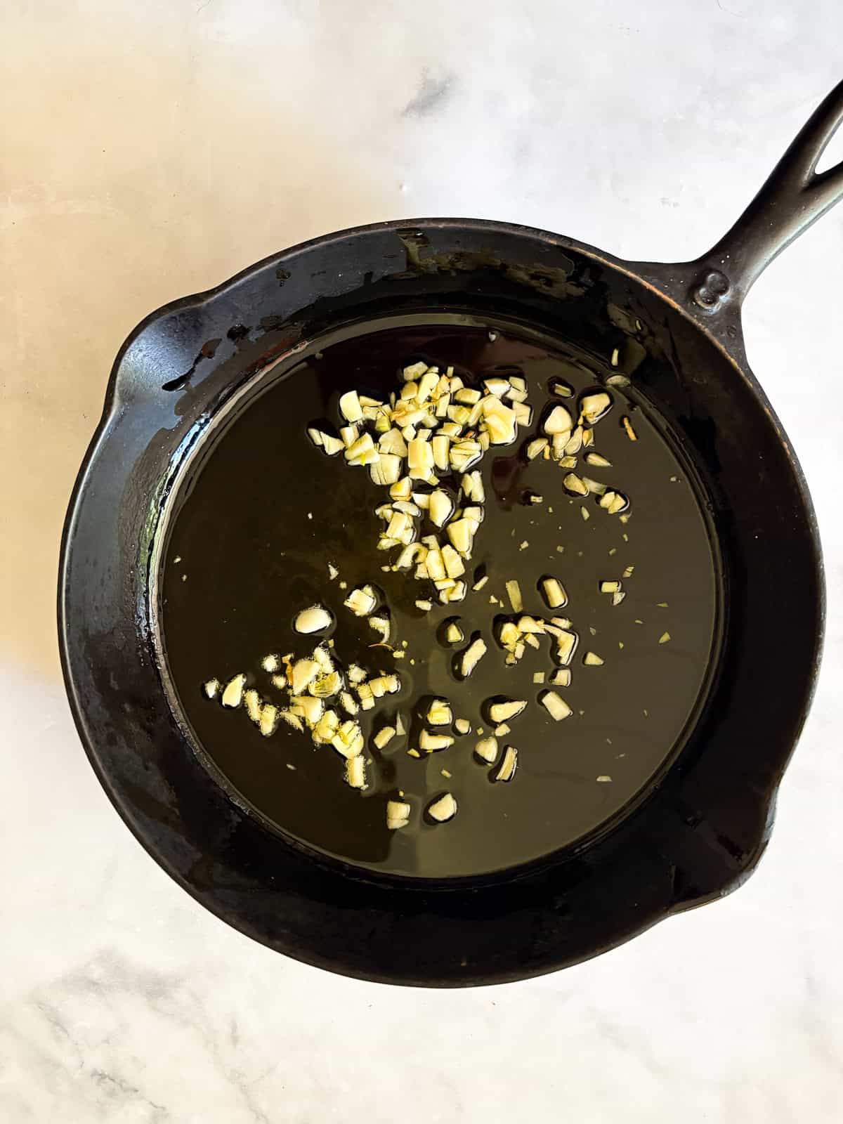 Garlicky white beans and kale are brightened up with lemon juice for a simple, satisfying, and QUICK vegetarian main. Garlic cooks in olive oil in a skillet.
