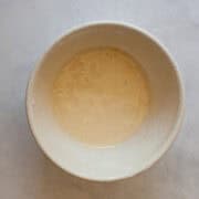 A small white bowl of orange glaze.