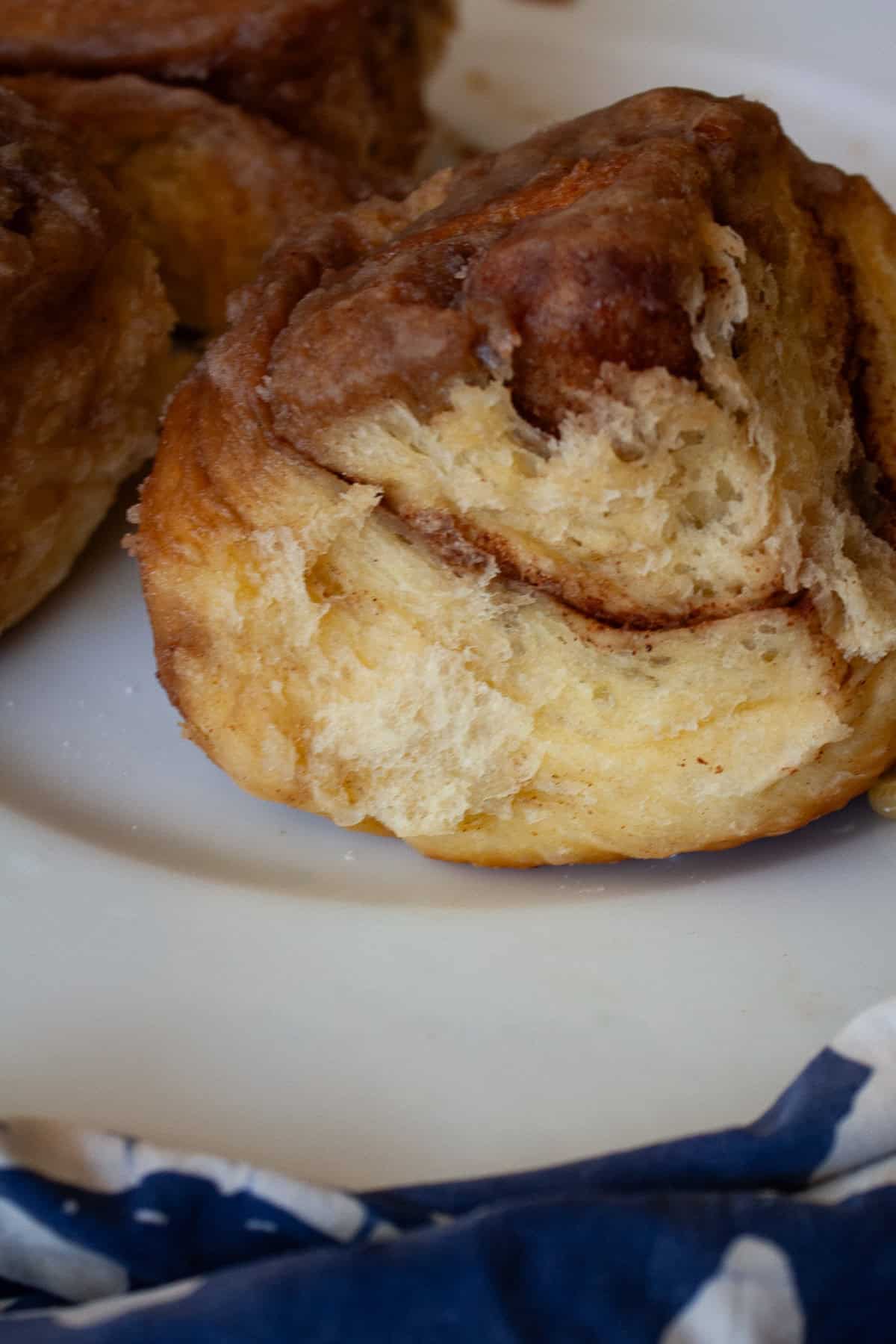 My homemade sticky buns recipe is make-ahead friendly and amazingly good! A thick maple syrup topping turns these into a bakery-worthy treat. The fluffy exterior of a sticky bun.