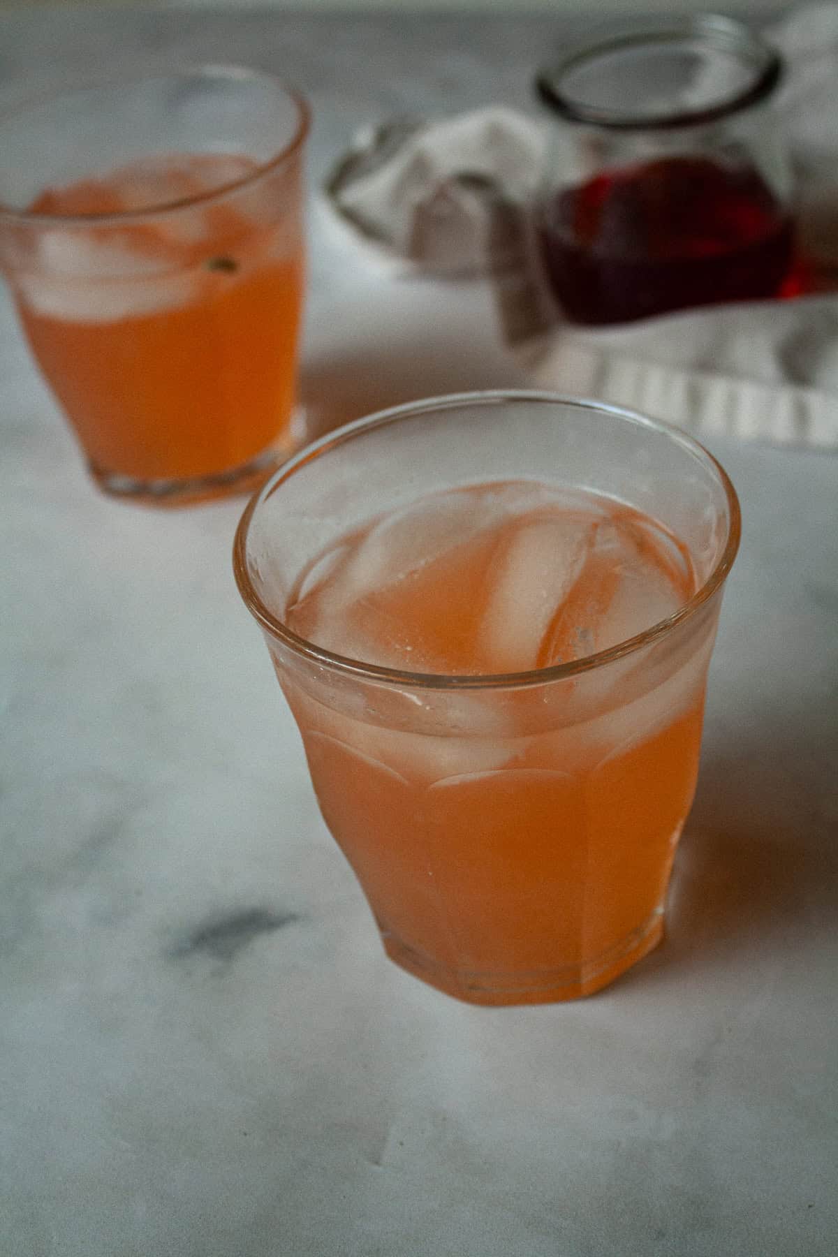 Two glasses of strawberry lemonade with ice.