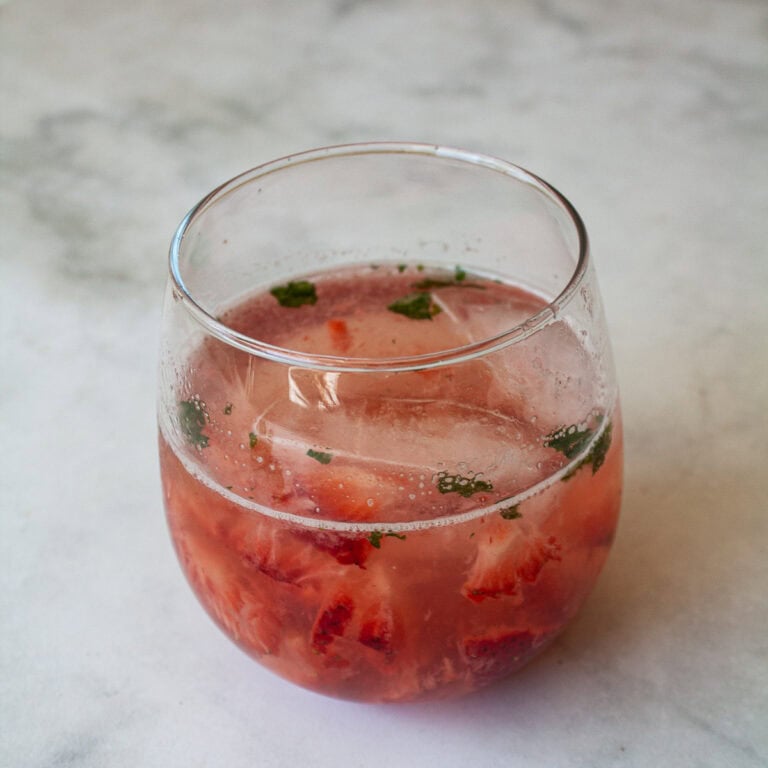 A glass of strawberry mocktail with mint.