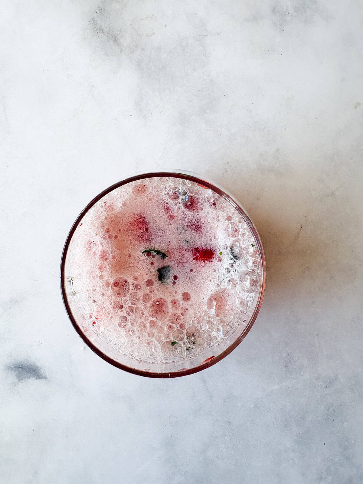 This strawberry mocktail is a not-too-sweet, non-alcoholic drink featuring juicy strawberries muddled with honey, lime, and mint. Sparkling water is added to a strawberry mocktail.