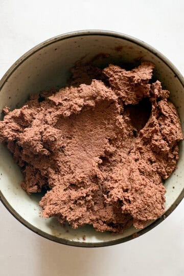 Chocolate cookie dough in a bowl, ready for baking.