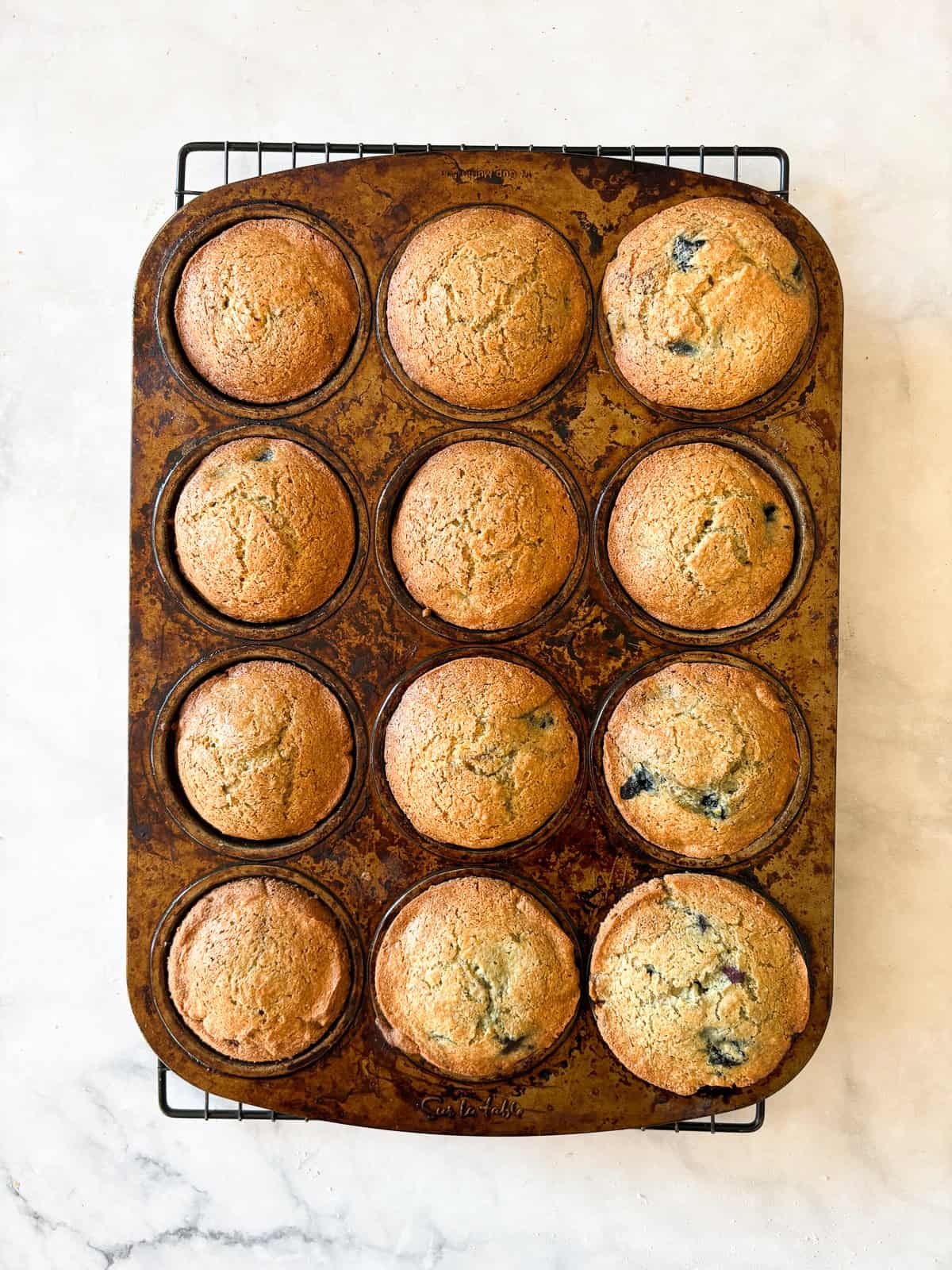 Sweet and tender gluten free lemon blueberry muffins feature loads of juicy berries, lemon zest, and an easy batter that bakes up perfectly. Whole wheat blueberry muffins cool in a muffin tin.