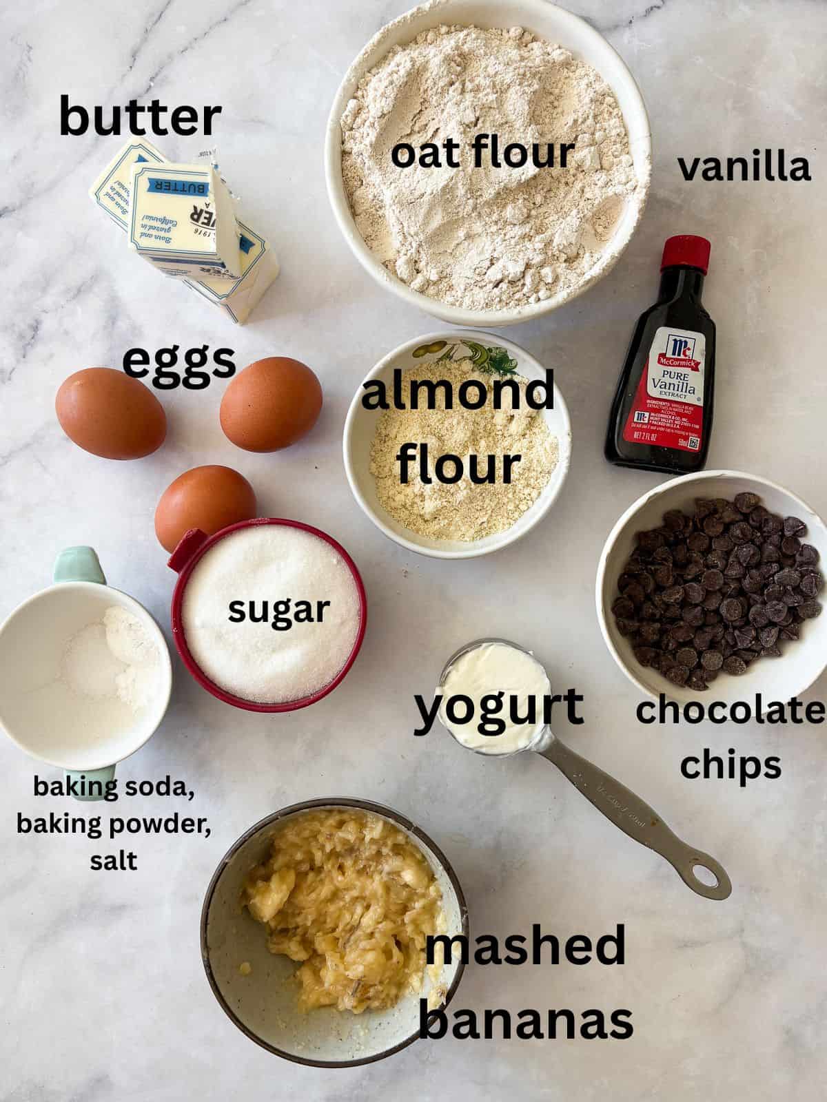 This rich, gluten free banana bundt cake is made with plenty of butter and sugar, then swirled with bananas and chocolate chips. Ingredients for banana bundt cake are text-labeled.