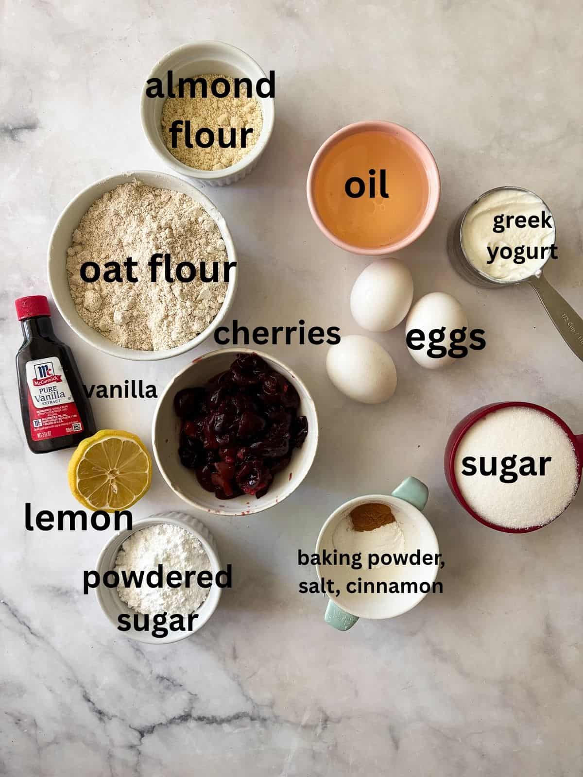 A recipe for a one-bowl gluten free cherry loaf cake that's swirled with chopped cherries and finished with a slick of tart lemon glaze. Ingredients for a gluten free cherry loaf cake are text-labeled.