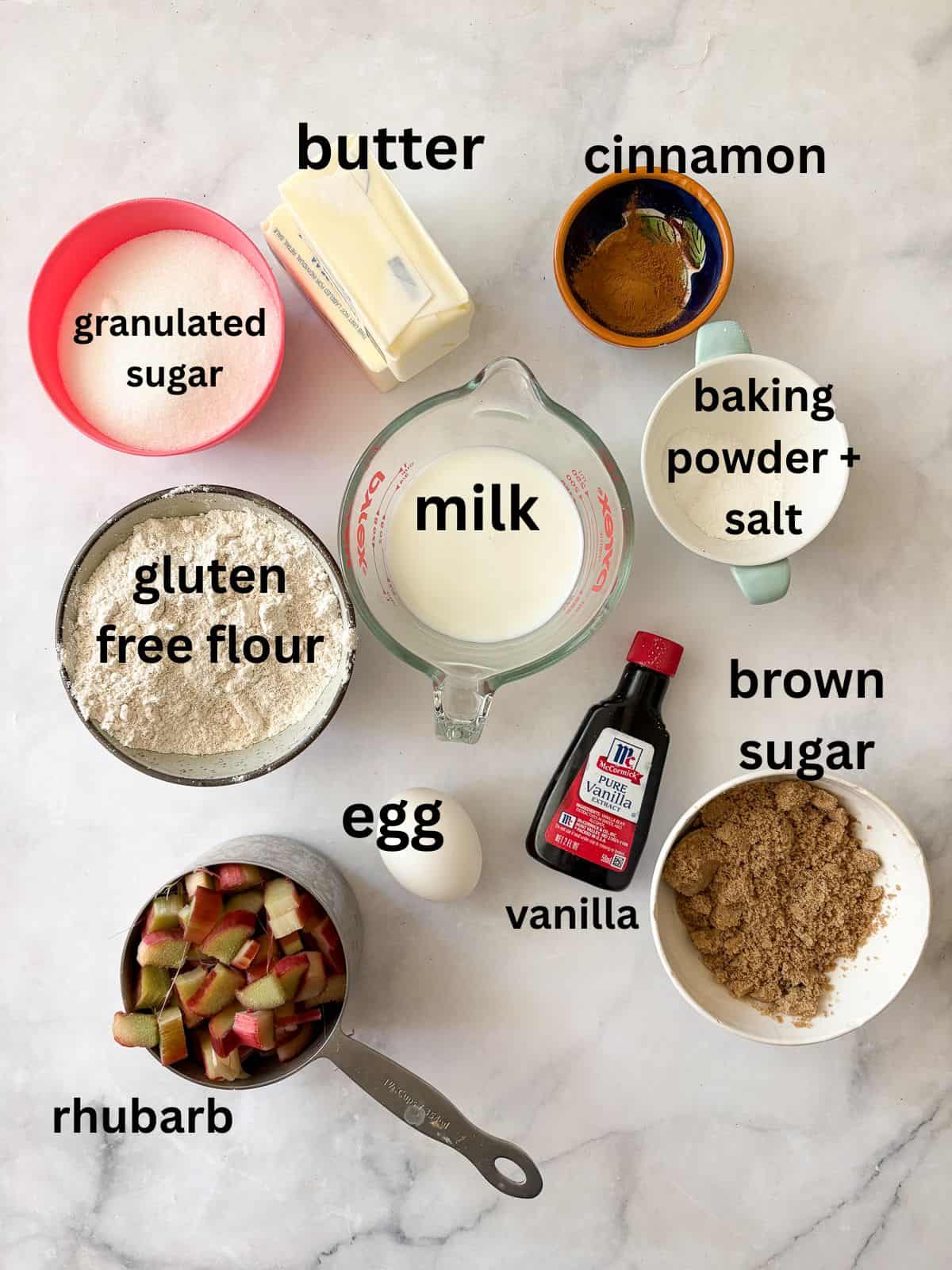 A soft and sweet gluten free rhubarb crumb cake with tart bits of rhubarb and a buttery, brown sugar streusel. Great for brunch! Ingredients for gluten free rhubarb crumb cake are text-labeled.