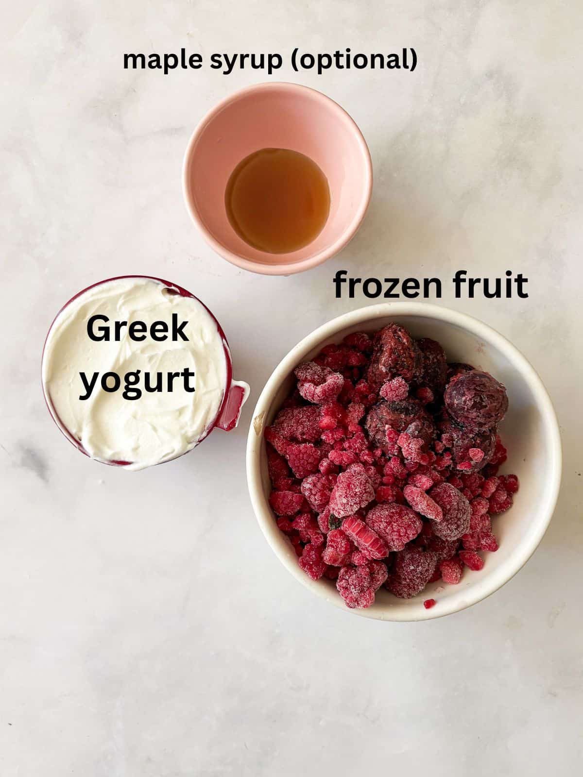 Just two ingredients - fruit and yogurt - plus a food processor are needed to make this refreshing and easy homemade Greek frozen yogurt. Ingredients for homemade Greek frozen yogurt are text-labeled.