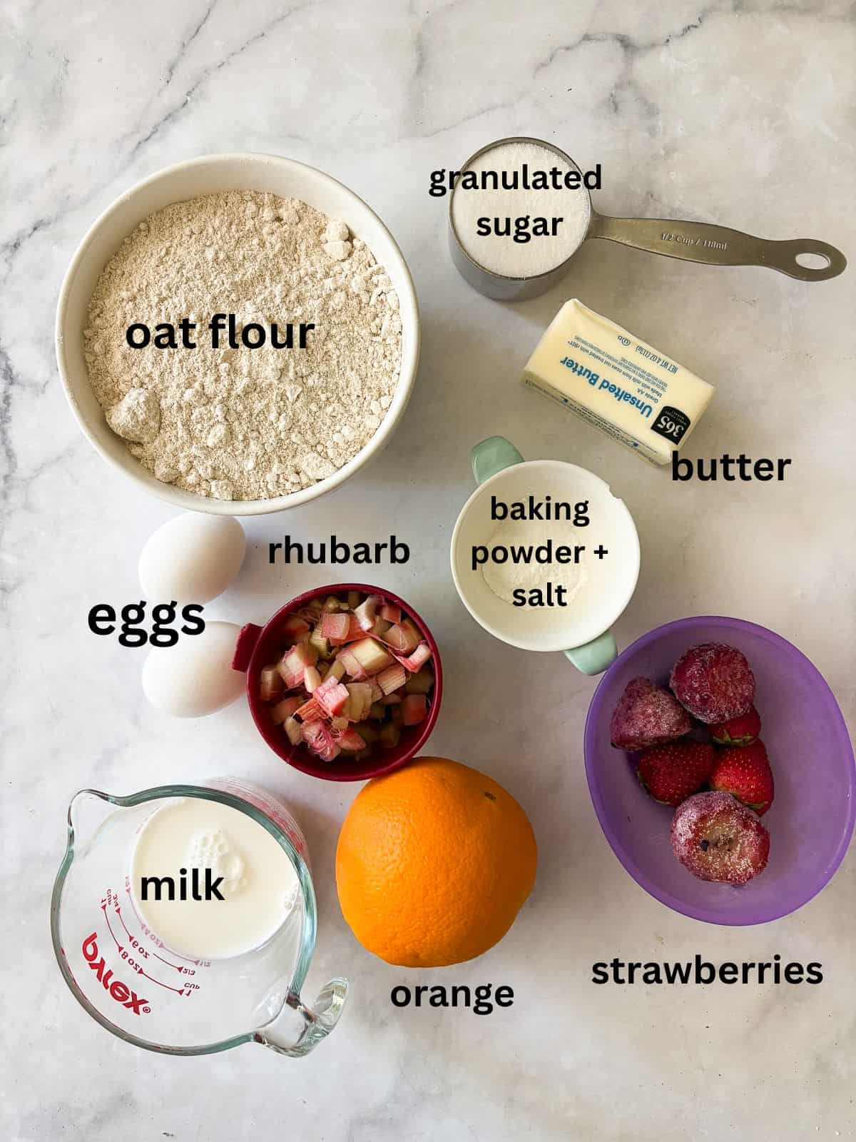 Tender and flaky whole grain strawberry rhubarb scones are a perfect summer morning treat. Make these with whole wheat or gf oat flour. Ingredients for strawberry rhubarb scones are text-labeled.