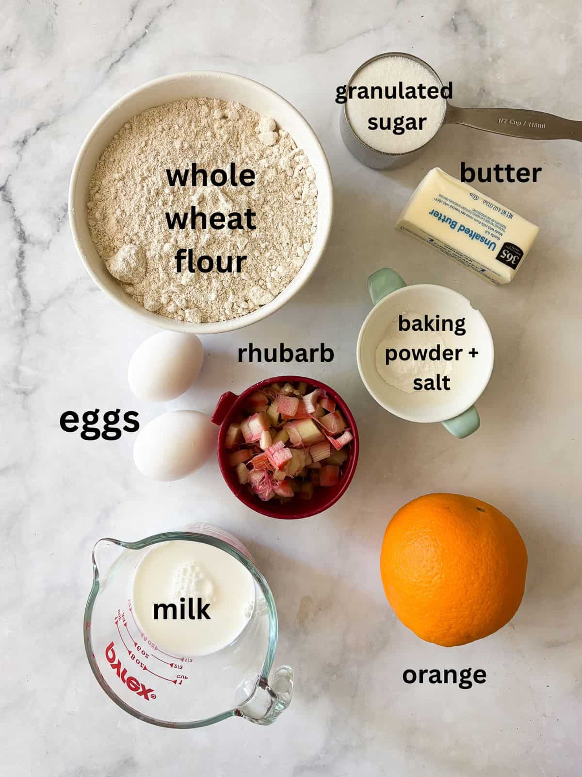 Tender, flaky rhubarb scones made with whole wheat flour and lots of tart spring rhubarb and a hint of orange zest. Ingredients for whole wheat rhubarb scones are text-labeled.