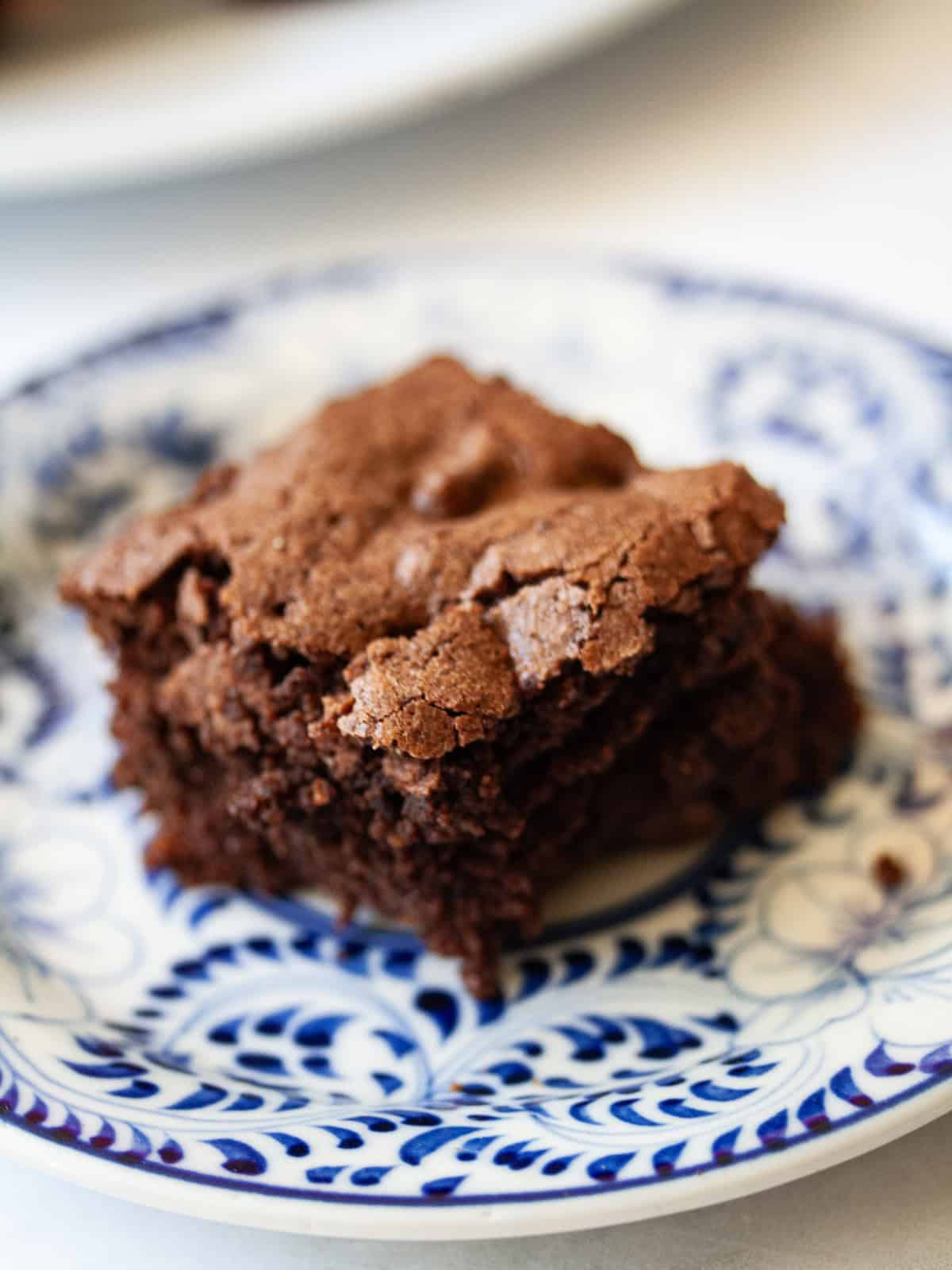 Deeply rich and chocolatey almond flour brownies are both grain-free and gluten-free. So much better than a boxed mix! An almond flour brownie on a plate.