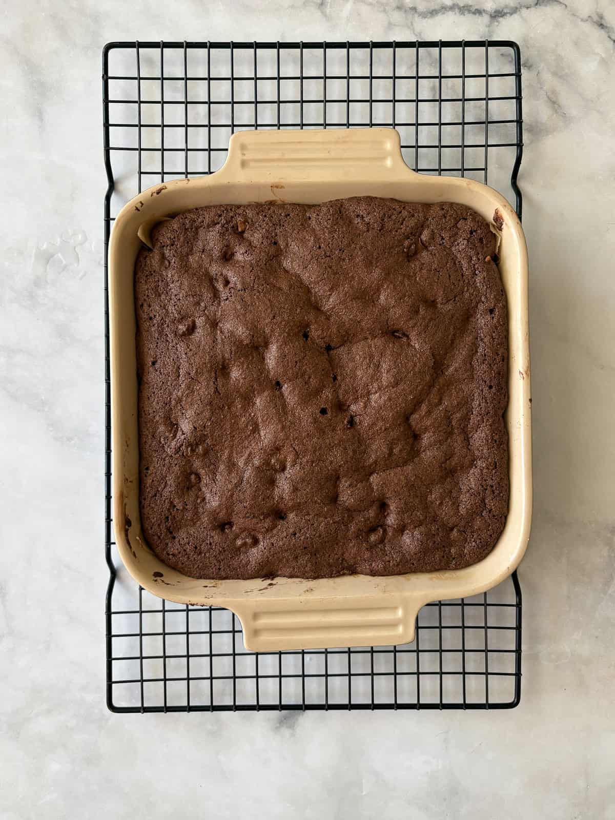 Deeply rich and chocolatey almond flour brownies are both grain-free and gluten-free. So much better than a boxed mix! A pan of almond flour brownies cools on a rack.
