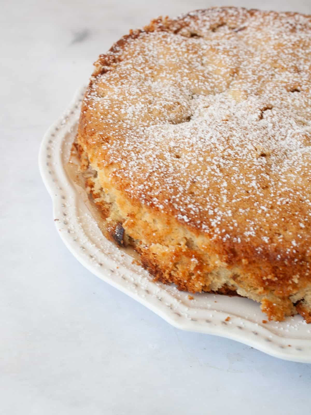 A nubbly and wholesome apple rhubarb cake that's made with whole-grain flour, yogurt, and plenty of juicy apples and tart rhubarb. An apple rhubarb cake on a plate.