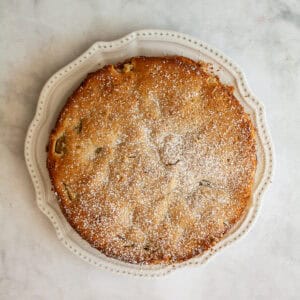 An apple rhubarb cake on a white plate.