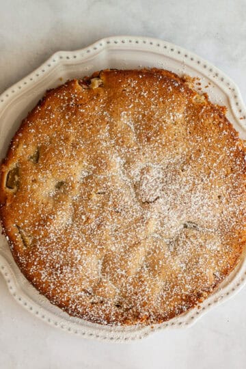 An apple rhubarb cake on a white plate.