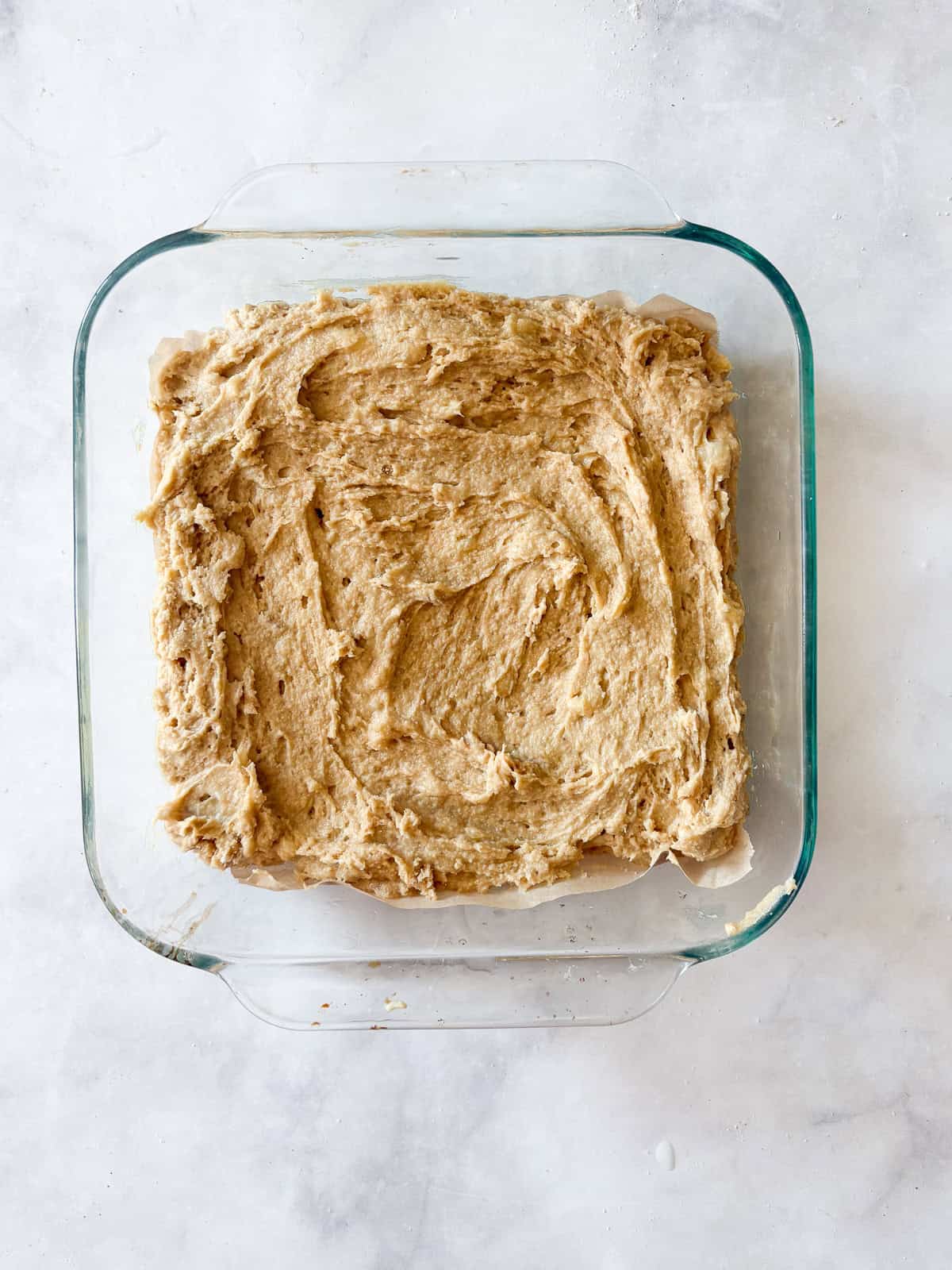 This banana snack cake is fluffy, moist, and balanced by warming spices. Naturally gluten-free, or make it with whole wheat flour. Banana snack cake batter in a pan.