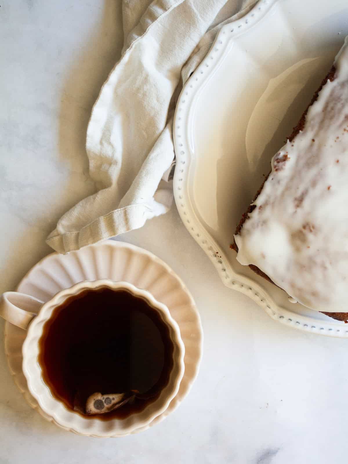 This pretty cherry bread is made in just one bowl and is finished with a lemon glaze. Whole grain flour, Greek yogurt - all the good stuff! A cup of dark tea next to a loaf of cherry bread.