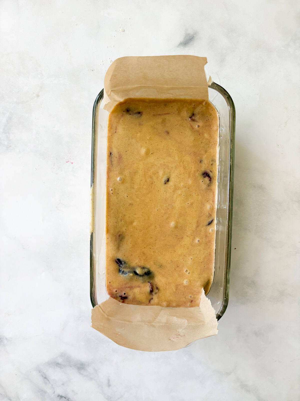 This pretty cherry bread is made in just one bowl and is finished with a lemon glaze. Whole grain flour, Greek yogurt - all the good stuff! Cherry bread batter in a loaf pan.