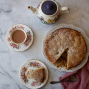 A tea pot and tea next to a gluten free apple and rhubarb cake.