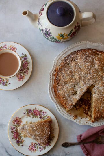 A tea pot and tea next to a gluten free apple and rhubarb cake.
