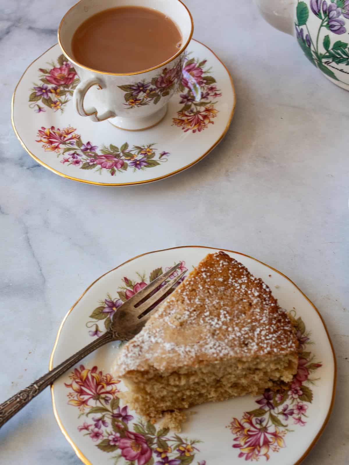 A slice of gluten free apple and rhubarb cake with a cup of tea.