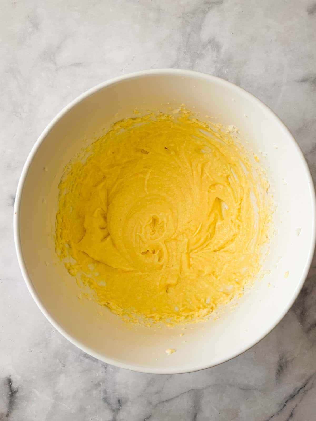 This pretty cake marries crisp, sweet apples with tart rhubarb to make a seasonal gluten free apple and rhubarb cake! Gluten free apple and rhubarb cake batter in a bowl.