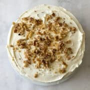 A gluten free hummingbird cake is topped with walnuts.