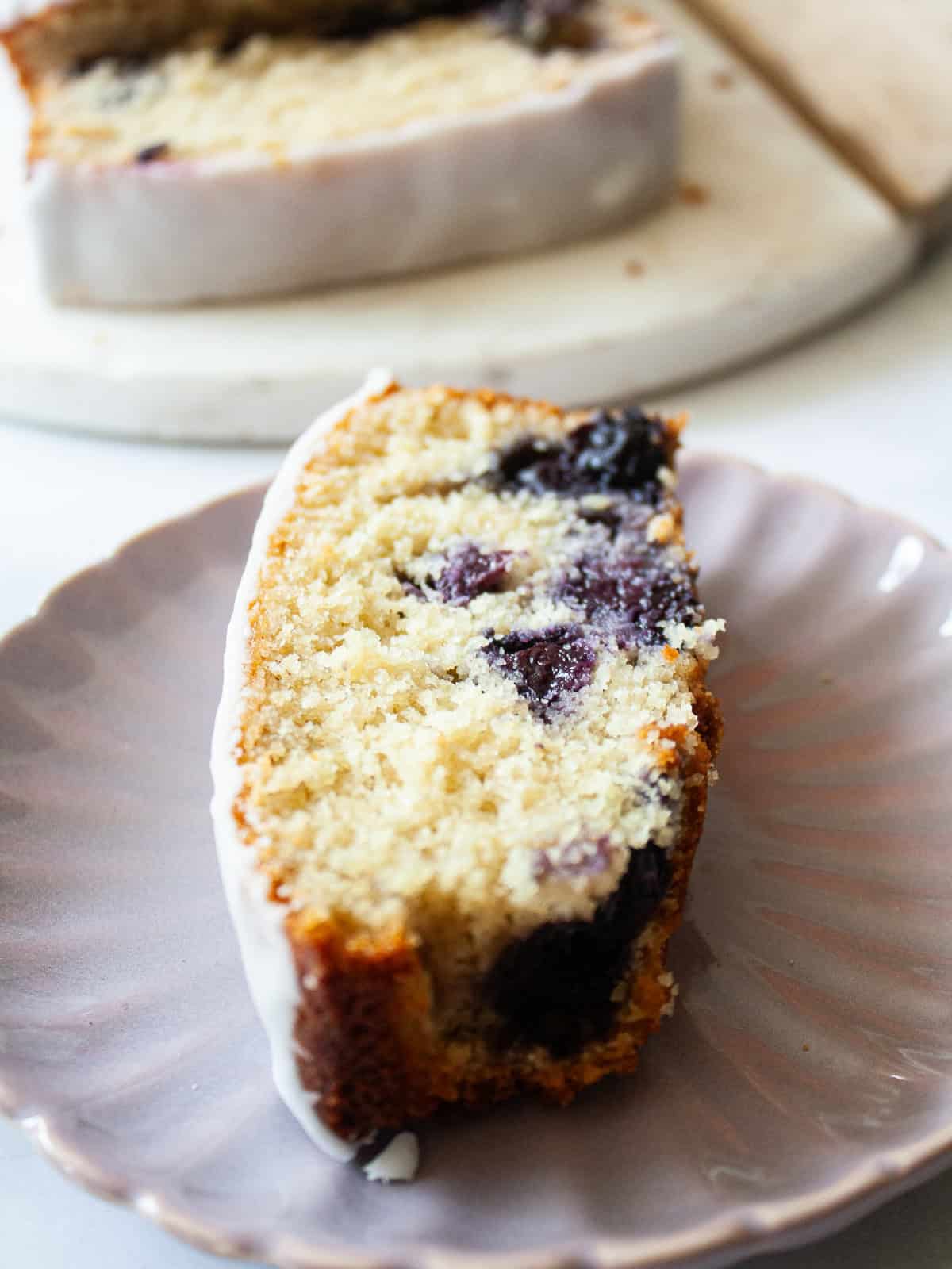 A slice of lemon blueberry loaf on a plate.