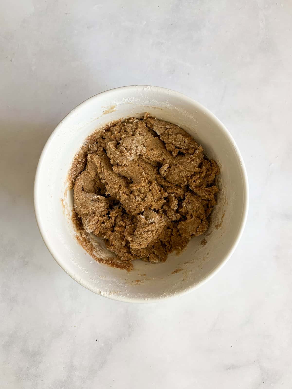 A soft and sweet gluten free rhubarb crumb cake with tart bits of rhubarb and a buttery, brown sugar streusel. Great for brunch! The crumb topping for gluten free rhubarb crumb cake in a bowl.
