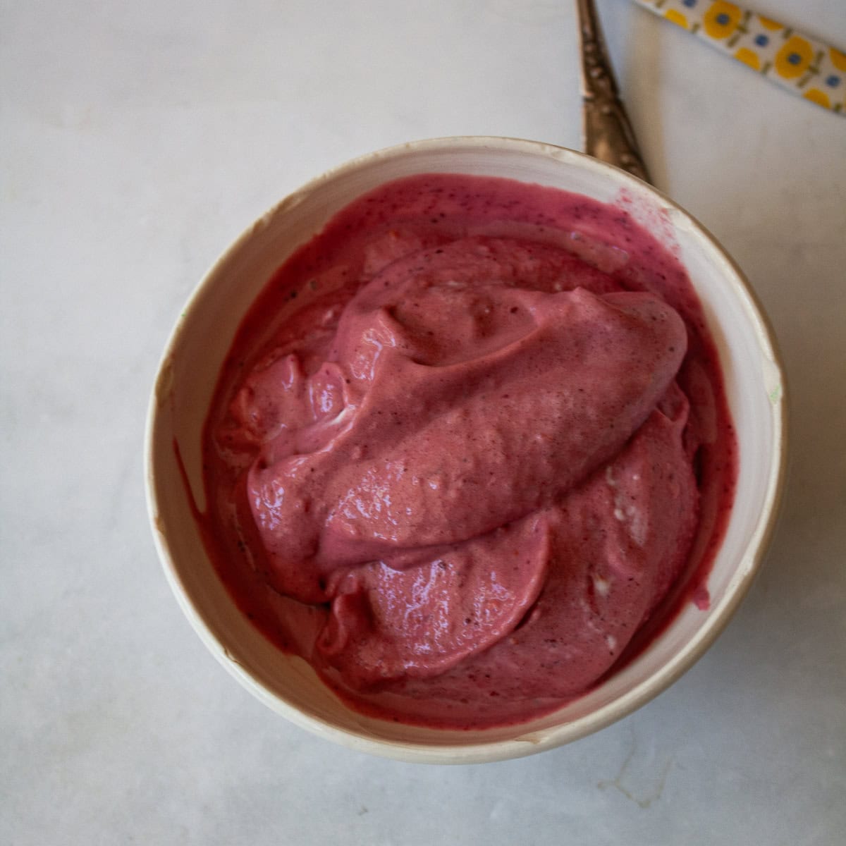 A white bowl full of homemade Greek frozen yogurt.
