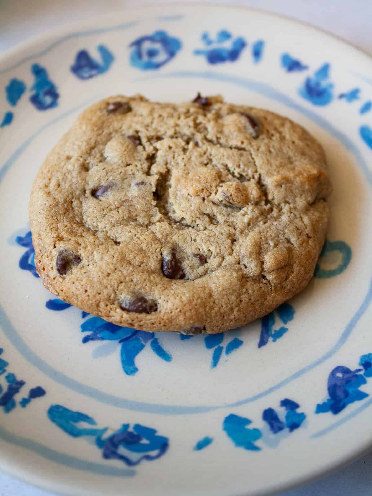 One of my favorite types of cookies, these maple chocolate chip cookies are sweetened with a combination of maple syrup and brown sugar. A maple syrup chocolate chip cookie on a plate.