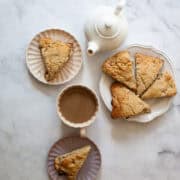 Oat flour rhubarb scones served on plates next to a tea pot.