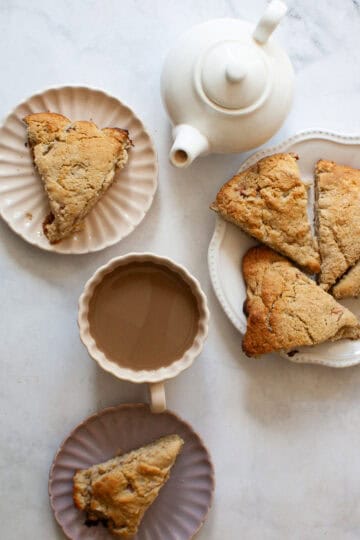 Oat flour rhubarb scones served on plates next to a tea pot.