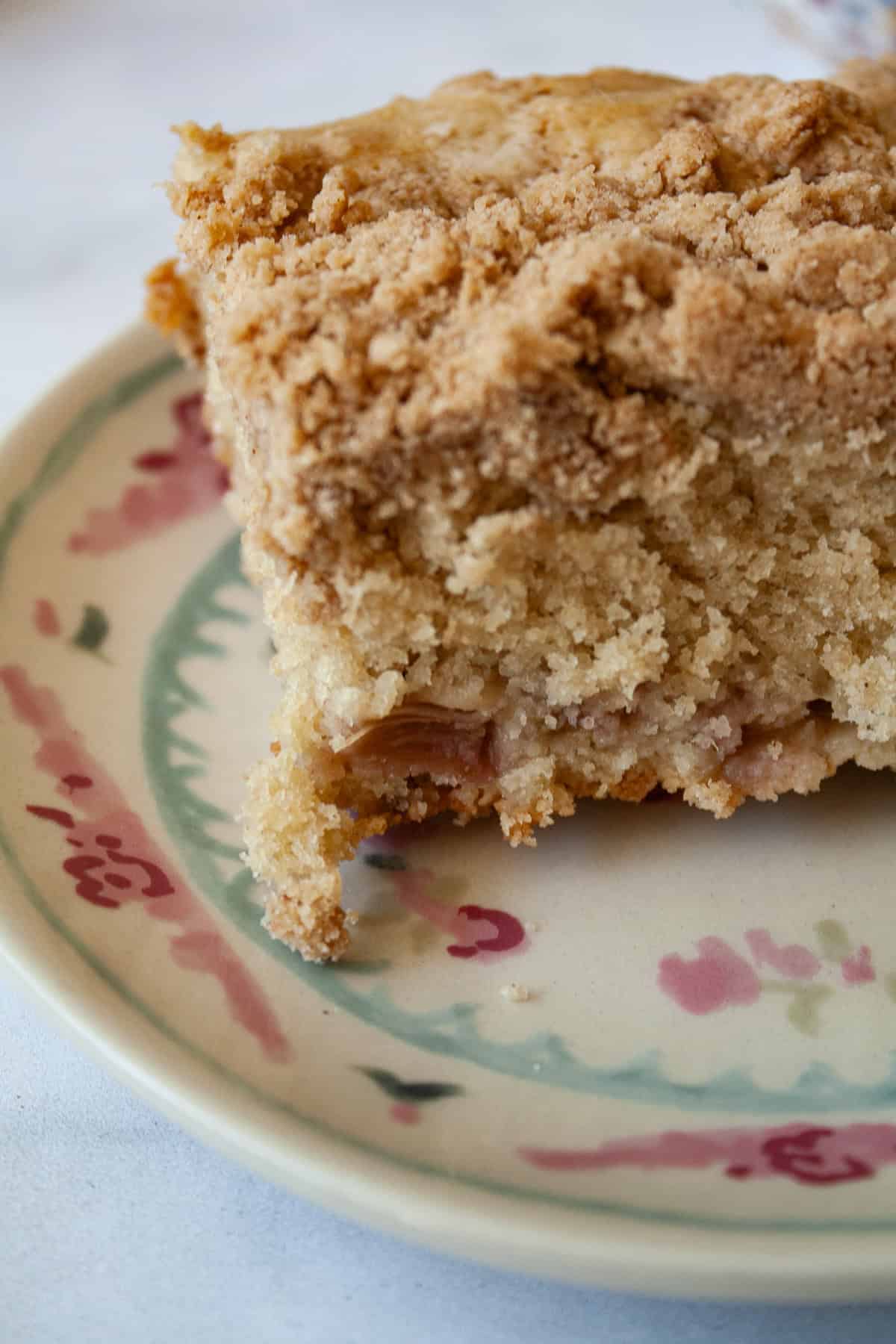 A piece of rhubarb crumb cake on a decorative plate.